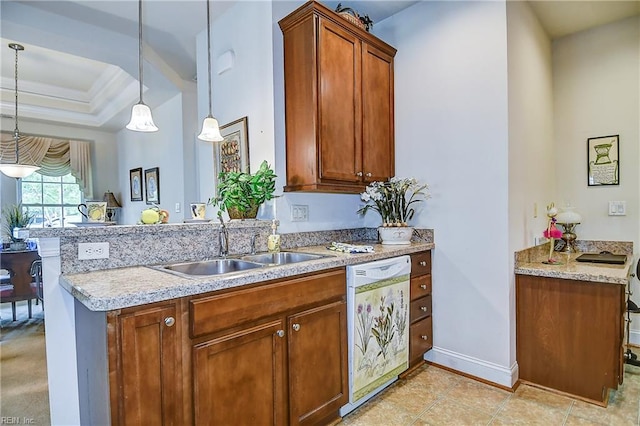 kitchen featuring white dishwasher, a sink, decorative light fixtures, and brown cabinetry