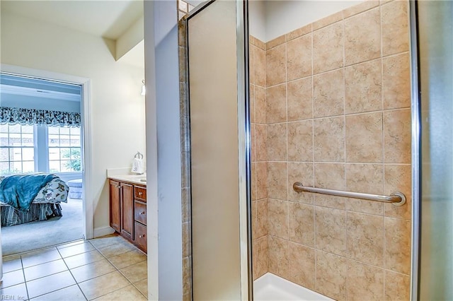 ensuite bathroom with a stall shower, tile patterned floors, and vanity