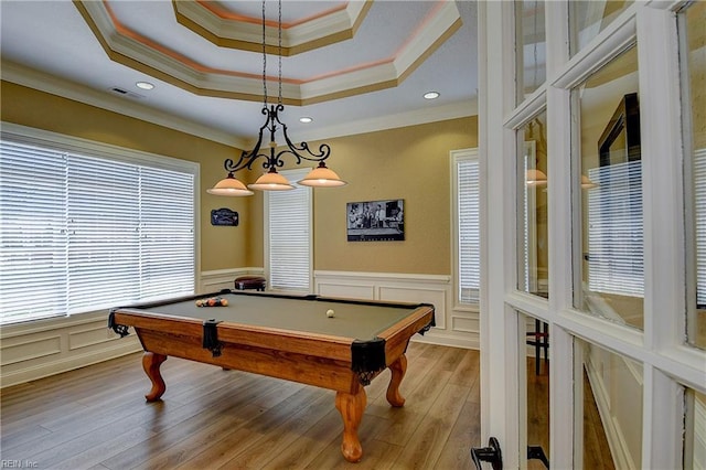 playroom with ornamental molding, a tray ceiling, wood finished floors, billiards, and a decorative wall