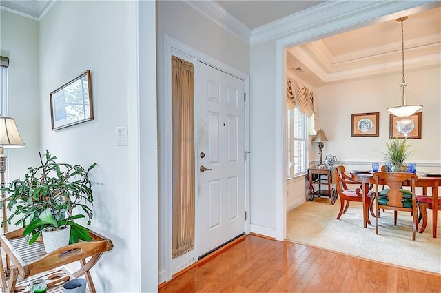 foyer entrance featuring hardwood / wood-style flooring, crown molding, and baseboards