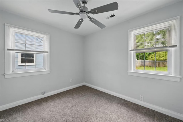 carpeted spare room featuring baseboards and a ceiling fan