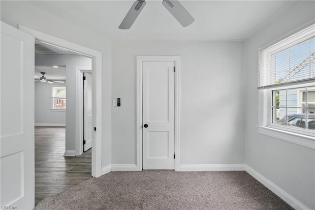 carpeted empty room featuring ceiling fan and baseboards