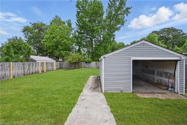 view of yard featuring a detached garage and an outbuilding