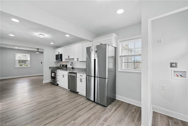 kitchen featuring appliances with stainless steel finishes, baseboards, white cabinets, recessed lighting, and a ceiling fan