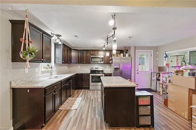1117 Perry St, Chesapeake, VA 23324 - kitchen with appliances with stainless steel finishes, a sink, dark brown cabinets, and light wood-style flooring
