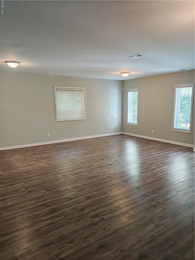 spare room with dark wood-style floors and baseboards
