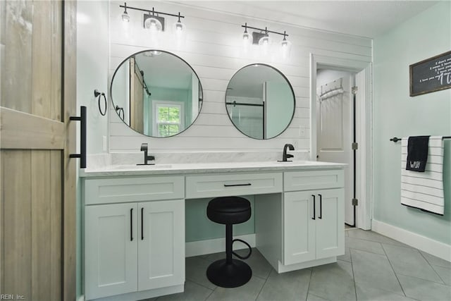 bathroom featuring tile patterned flooring, baseboards, and double vanity