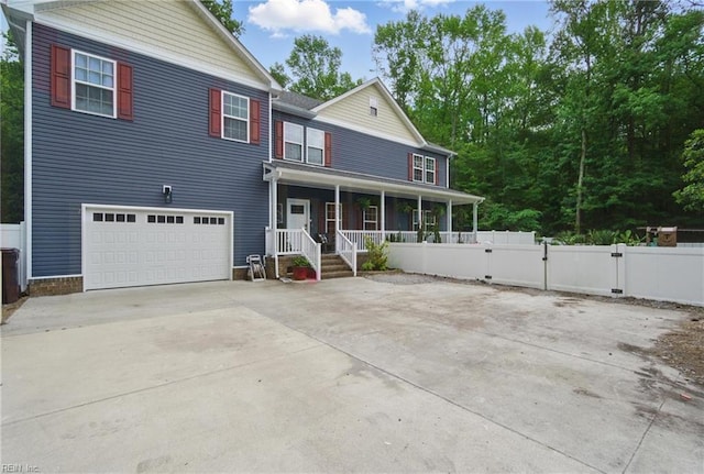 view of front of home with covered porch, an attached garage, concrete driveway, and fence
