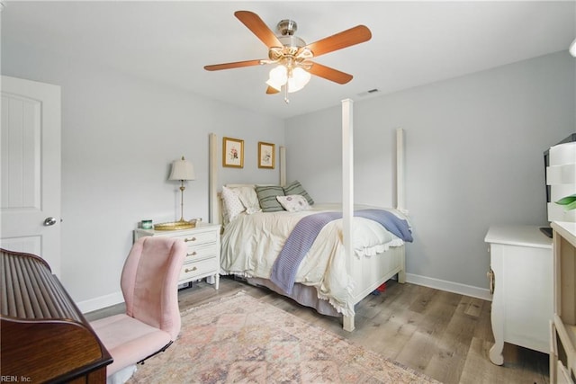 bedroom with light wood-style floors, baseboards, and a ceiling fan