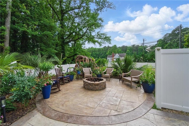 view of patio featuring a fire pit and fence