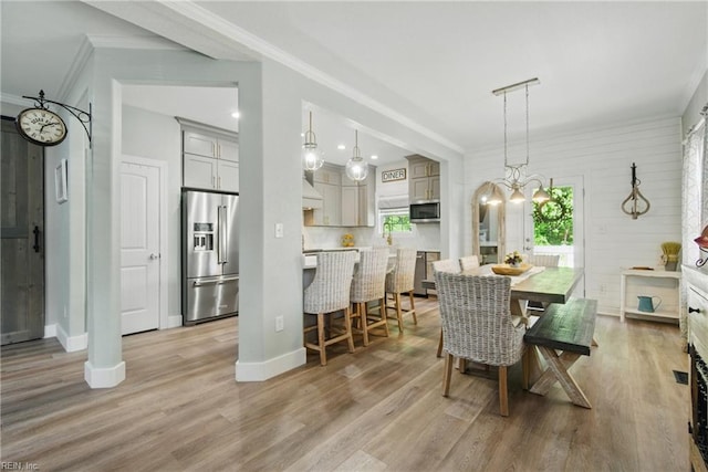 dining space featuring crown molding, light wood-style flooring, baseboards, and recessed lighting