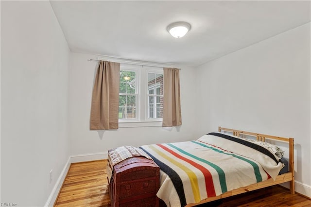 bedroom featuring baseboards and wood finished floors
