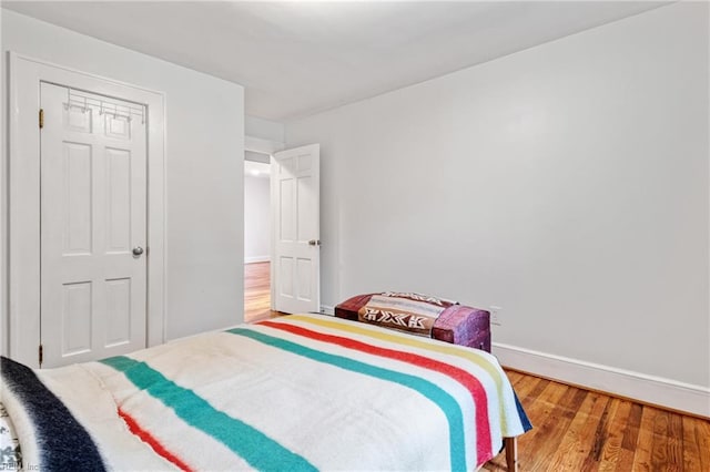 bedroom with wood finished floors and baseboards