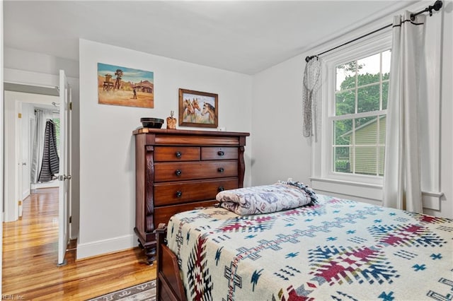 bedroom with light wood finished floors and baseboards