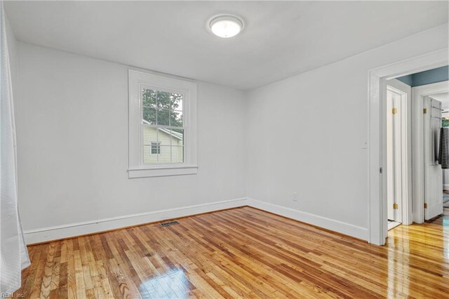 spare room featuring light wood finished floors and baseboards