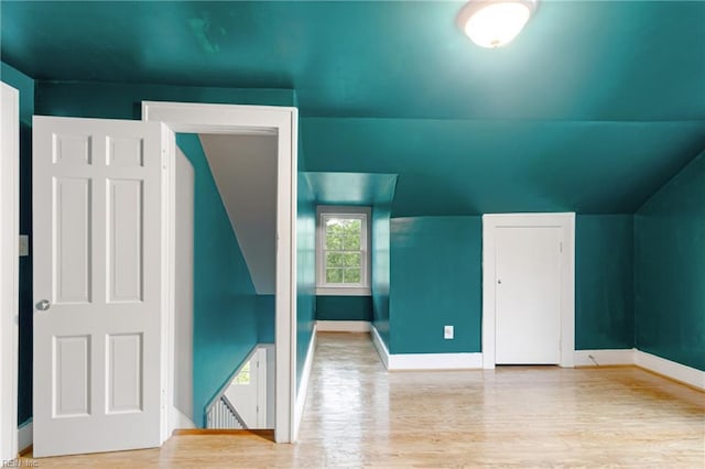 bonus room featuring wood finished floors, lofted ceiling, and baseboards