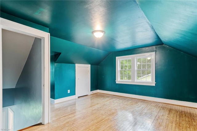 bonus room with wood finished floors, lofted ceiling, and baseboards