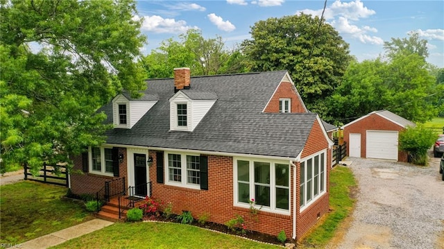 cape cod home with an outdoor structure, brick siding, a garage, and roof with shingles