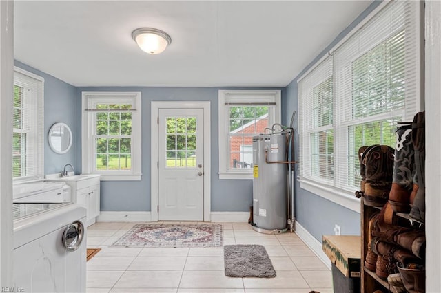 sunroom / solarium with water heater, a sink, and independent washer and dryer