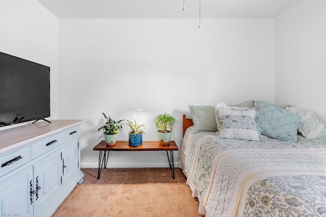 bedroom featuring light colored carpet and baseboards