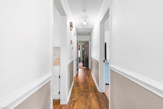 hallway with attic access and dark wood-style flooring