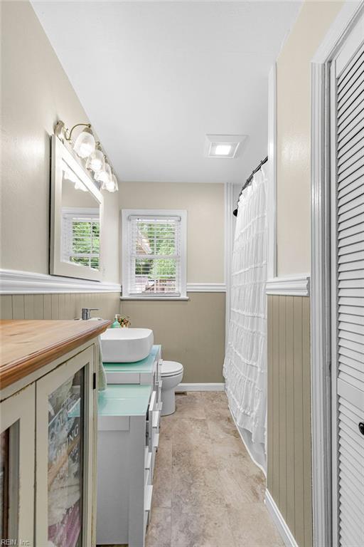 full bathroom with toilet, vanity, baseboards, and a shower with shower curtain