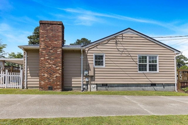 view of home's exterior featuring crawl space, a chimney, and fence