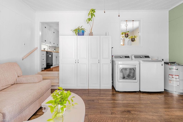 clothes washing area featuring water heater, washing machine and dryer, ornamental molding, and wood finished floors