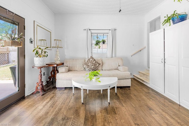 living room with ornamental molding, wood finished floors, plenty of natural light, and stairway