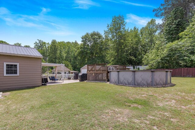 view of yard featuring an outdoor pool, a deck, and a patio area