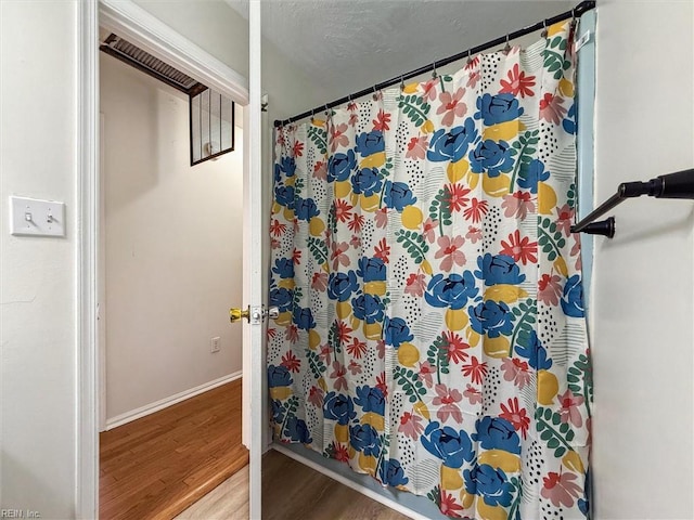 7103 Orcutt Ave, Newport News, VA 23605 - bathroom with wood finished floors, baseboards, and a shower with shower curtain