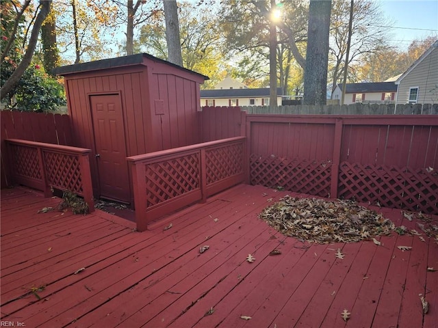 deck featuring a shed, an outbuilding, and fence