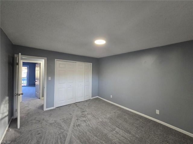 unfurnished bedroom with carpet, baseboards, a closet, and a textured ceiling