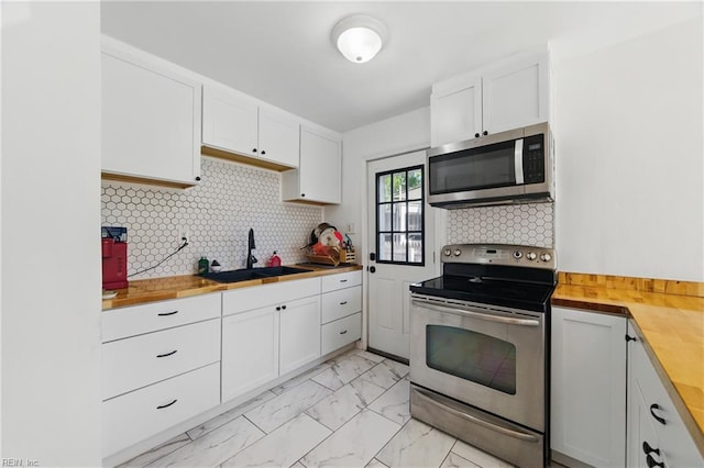 7811 Nesbitt Dr, Norfolk, VA 23505 - kitchen featuring stainless steel appliances, a sink, butcher block countertops, and light marble finish floors