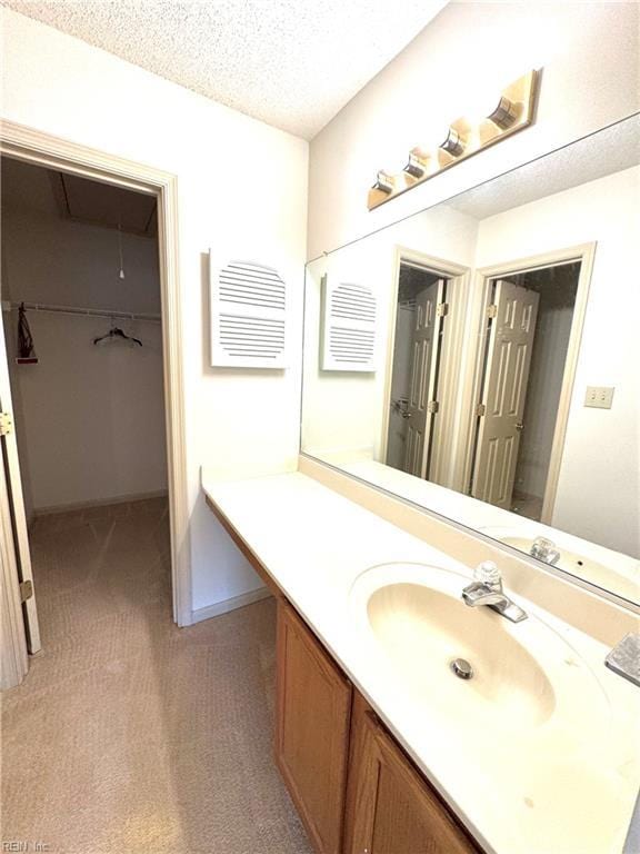 121 Monarch Glade, Yorktown, VA 23692 - bathroom with vanity, a textured ceiling, and a walk in closet