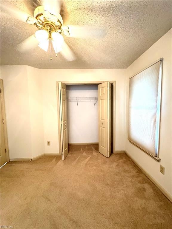 121 Monarch Glade, Yorktown, VA 23692 - unfurnished bedroom with a textured ceiling, light carpet, a closet, a ceiling fan, and baseboards