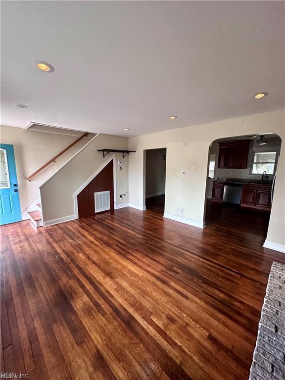 1355 W Norcova Dr, Norfolk, VA 23502 - unfurnished living room with dark wood finished floors, arched walkways, baseboards, recessed lighting, and stairs