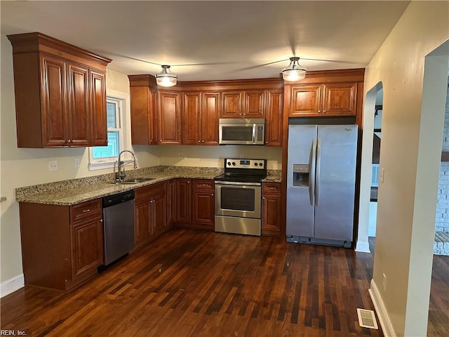 1355 W Norcova Dr, Norfolk, VA 23502 - kitchen featuring appliances with stainless steel finishes, a sink, dark wood finished floors, arched walkways, and light stone counters