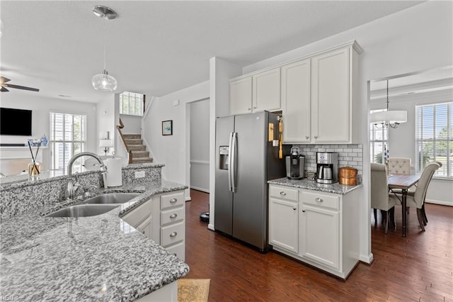 kitchen with stainless steel refrigerator with ice dispenser, a sink, white cabinets, and healthy amount of natural light