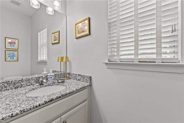 half bathroom featuring healthy amount of natural light and vanity