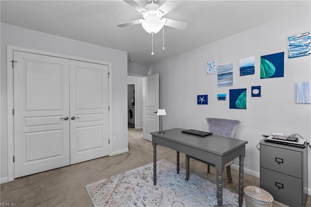 office with light colored carpet, baseboards, a ceiling fan, and washer / dryer
