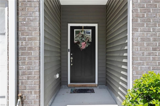property entrance featuring brick siding