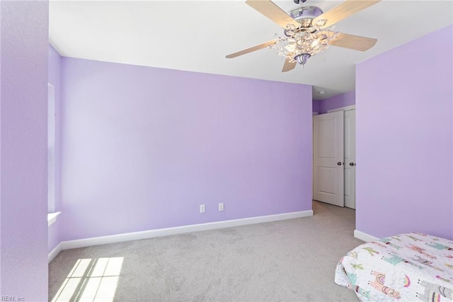 unfurnished bedroom featuring carpet floors, baseboards, and ceiling fan