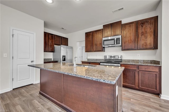 122 American Way, Suffolk, VA 23434 - kitchen featuring appliances with stainless steel finishes, a sink, light wood-style flooring, light stone counters, and recessed lighting