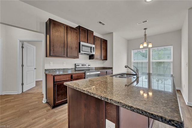 122 American Way, Suffolk, VA 23434 - kitchen featuring appliances with stainless steel finishes, a sink, light wood-style flooring, and dark stone countertops