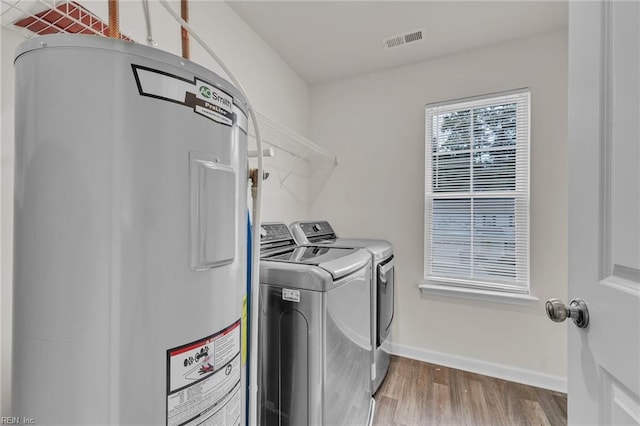 122 American Way, Suffolk, VA 23434 - laundry area with water heater, washer and dryer, wood finished floors, and baseboards
