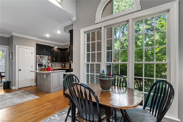 dining area featuring crown molding, light wood finished floors, baseboards, and recessed lighting