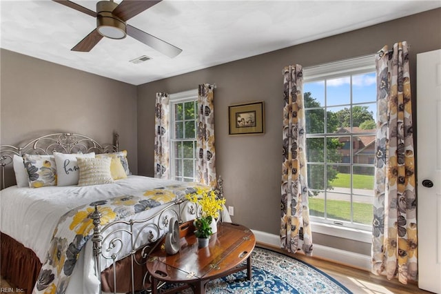 bedroom featuring wood finished floors, baseboards, and ceiling fan