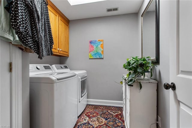 laundry area with washing machine and dryer, baseboards, and cabinet space