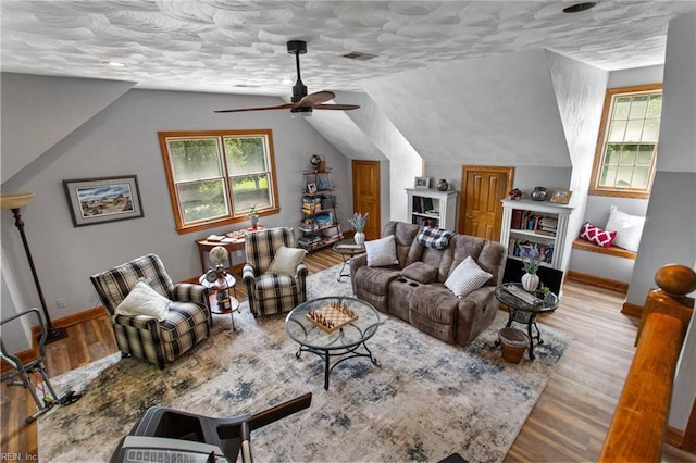 living room with baseboards, wood finished floors, ceiling fan, and lofted ceiling